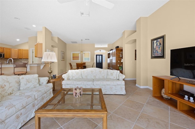 living area featuring a ceiling fan, baseboards, and light tile patterned floors