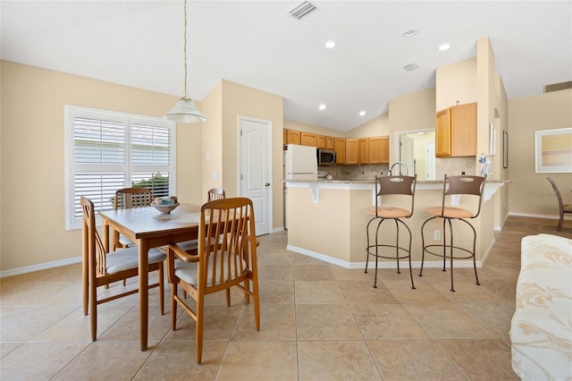 dining room with vaulted ceiling, light tile patterned floors, baseboards, and recessed lighting
