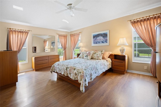 bedroom with wood finished floors, baseboards, and ceiling fan