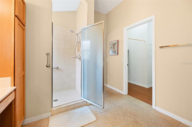 bathroom with a shower stall, tile patterned floors, vanity, and baseboards