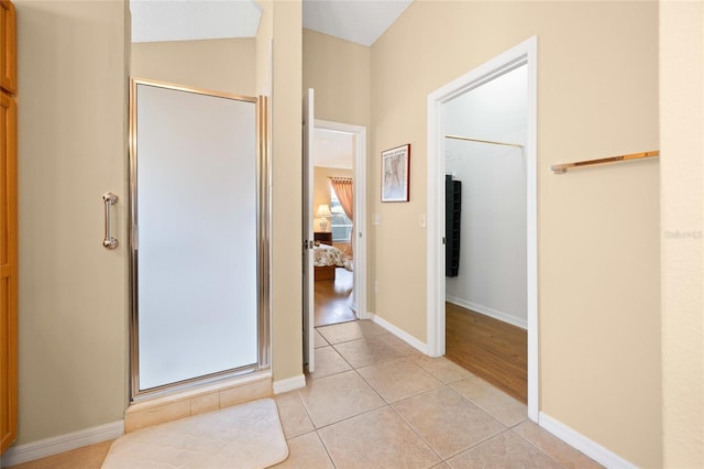 full bath featuring a stall shower, tile patterned floors, ensuite bath, and baseboards