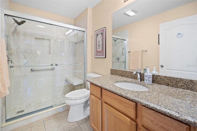 full bathroom featuring toilet, a stall shower, vanity, tile patterned floors, and a textured ceiling