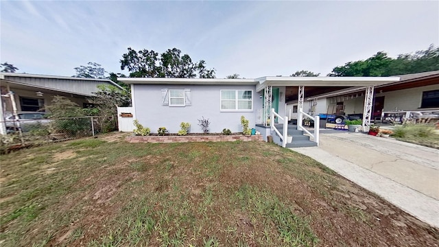 view of front of house featuring a carport, stucco siding, and concrete driveway