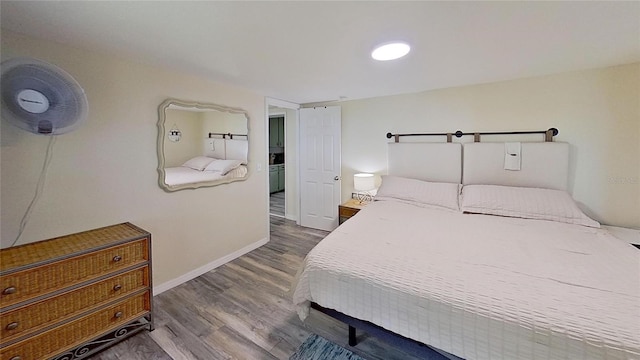 bedroom with wood finished floors and baseboards