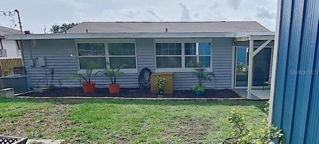 back of property with a lawn and central AC unit