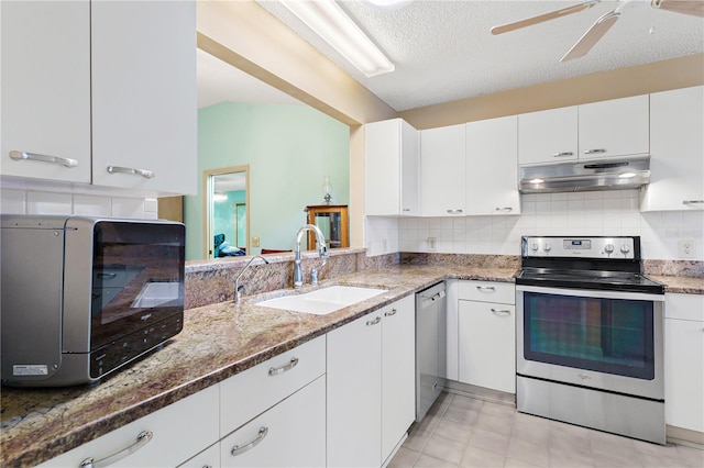 735 Palma Dr, The Villages, FL 32159 - kitchen with appliances with stainless steel finishes, under cabinet range hood, a sink, light stone counters, and white cabinetry