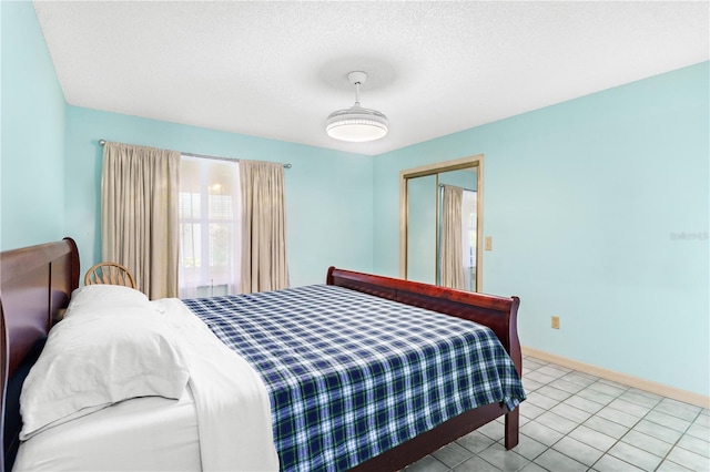 735 Palma Dr, The Villages, FL 32159 - bedroom with a closet, baseboards, a textured ceiling, and tile patterned flooring