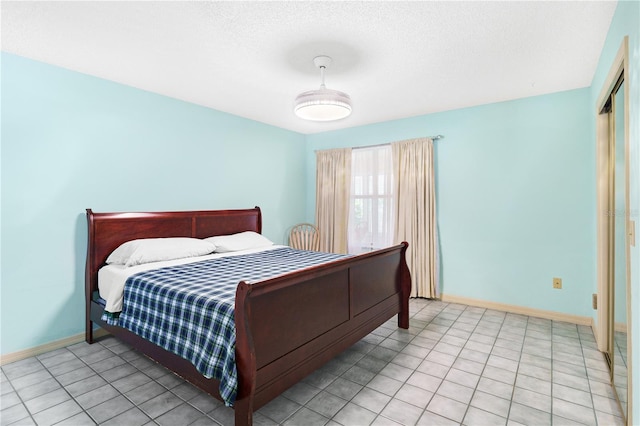 735 Palma Dr, The Villages, FL 32159 - bedroom featuring baseboards, a textured ceiling, and light tile patterned floors
