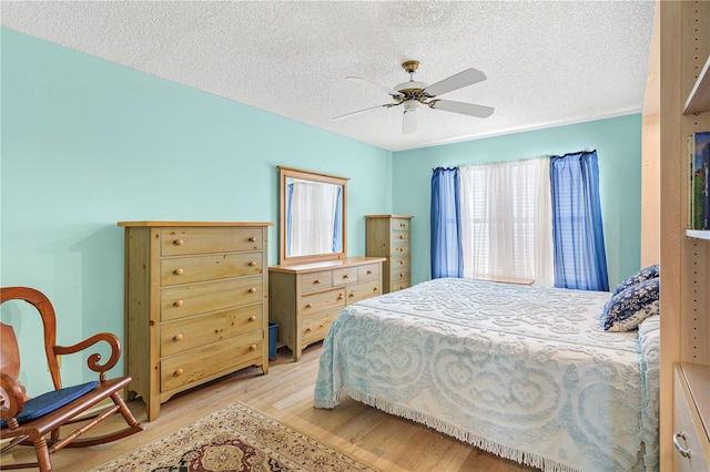 735 Palma Dr, The Villages, FL 32159 - bedroom featuring light wood finished floors, a textured ceiling, and ceiling fan