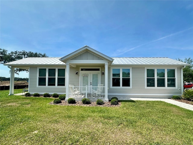 12077 Lakeshore Way, Oxford, FL 34484 - view of front of home featuring a front yard, a standing seam roof, metal roof, and french doors