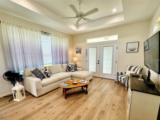12077 Lakeshore Way, Oxford, FL 34484 - living room with light wood-style flooring, french doors, a tray ceiling, and ceiling fan