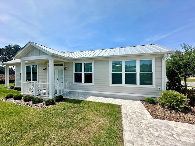 12077 Lakeshore Way, Oxford, FL 34484 - view of front of home featuring covered porch, a standing seam roof, a front lawn, and metal roof