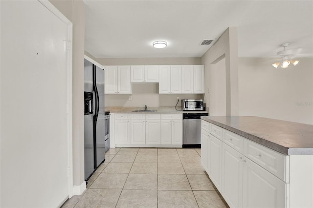 2423 Branch Way Unit 207, Maitland, FL 32751 - kitchen with appliances with stainless steel finishes, a sink, light tile patterned flooring, white cabinetry, and a ceiling fan
