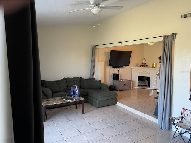 206 Orchid Dr, Davenport, FL 33897 - living room featuring ceiling fan, a fireplace with raised hearth, and light tile patterned floors