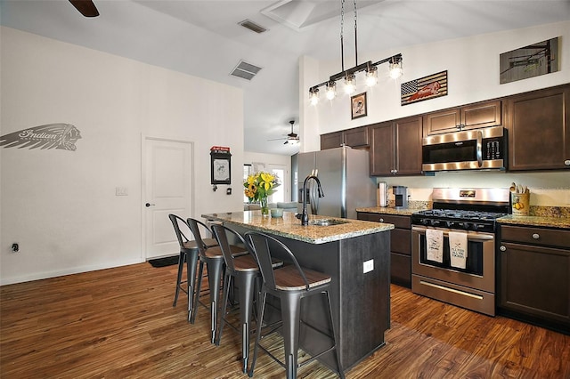 1204 Monterey Dr, Eustis, FL 32726 - kitchen featuring stainless steel appliances, high vaulted ceiling, a ceiling fan, a sink, and a kitchen breakfast bar