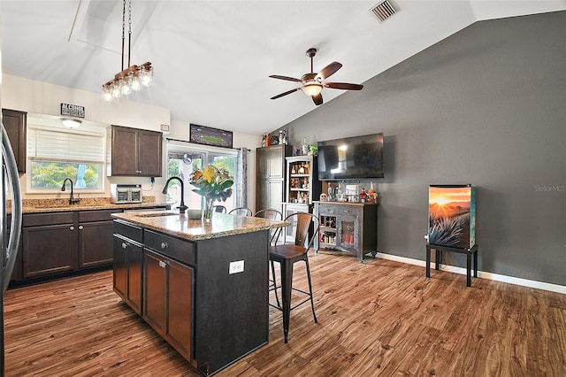 1204 Monterey Dr, Eustis, FL 32726 - kitchen with lofted ceiling, a breakfast bar area, ceiling fan, a sink, and dark wood finished floors
