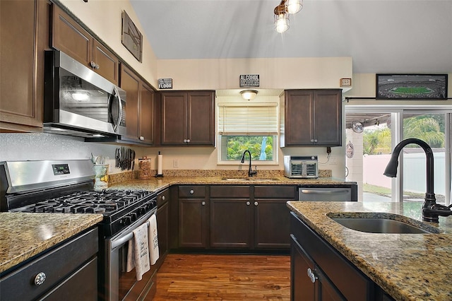 1204 Monterey Dr, Eustis, FL 32726 - kitchen featuring stainless steel appliances, a sink, dark stone countertops, and dark brown cabinets