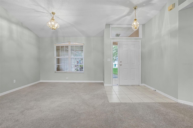 2711 Bayview Dr, Eustis, FL 32726 - carpeted foyer with a chandelier, tile patterned flooring, and baseboards
