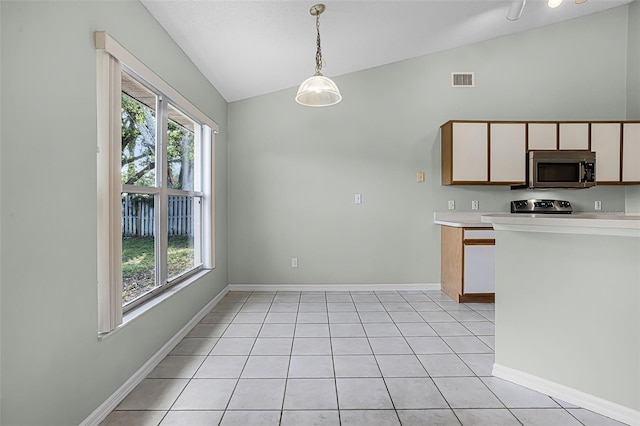 2711 Bayview Dr, Eustis, FL 32726 - kitchen featuring stainless steel microwave, lofted ceiling, range with electric stovetop, plenty of natural light, and light countertops