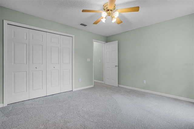 2711 Bayview Dr, Eustis, FL 32726 - unfurnished bedroom with baseboards, carpet, a closet, ceiling fan, and a textured ceiling