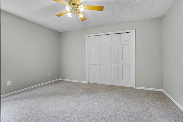 2711 Bayview Dr, Eustis, FL 32726 - unfurnished bedroom featuring carpet floors, a textured ceiling, a closet, baseboards, and ceiling fan