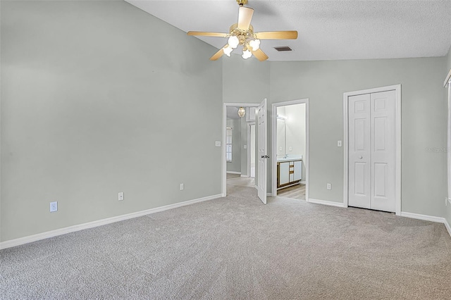 2711 Bayview Dr, Eustis, FL 32726 - unfurnished bedroom with carpet flooring, baseboards, a ceiling fan, a textured ceiling, and high vaulted ceiling