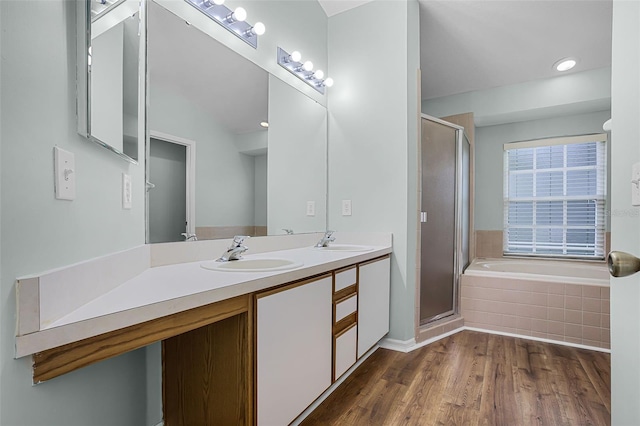 2711 Bayview Dr, Eustis, FL 32726 - bathroom with double vanity, a stall shower, a bath, and wood finished floors