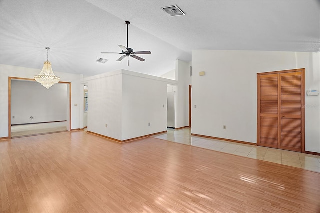 501 Cherry Tree St, Eustis, FL 32726 - unfurnished living room with ceiling fan, a chandelier, vaulted ceiling, light wood finished floors, and baseboards