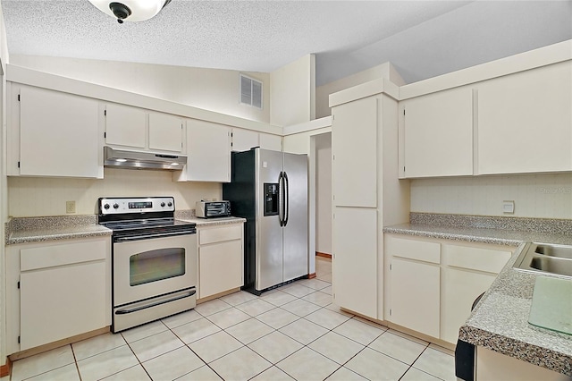 501 Cherry Tree St, Eustis, FL 32726 - kitchen with appliances with stainless steel finishes, under cabinet range hood, a textured ceiling, light tile patterned floors, and high vaulted ceiling