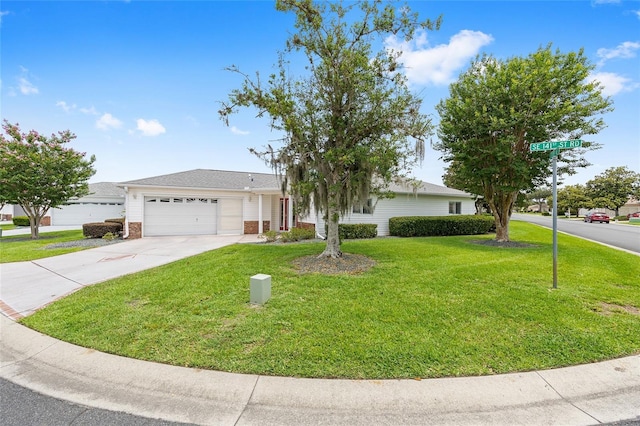 8608 SE 141st Street Rd, Summerfield, FL 34491 - view of front of property featuring concrete driveway, an attached garage, a front lawn, and brick siding