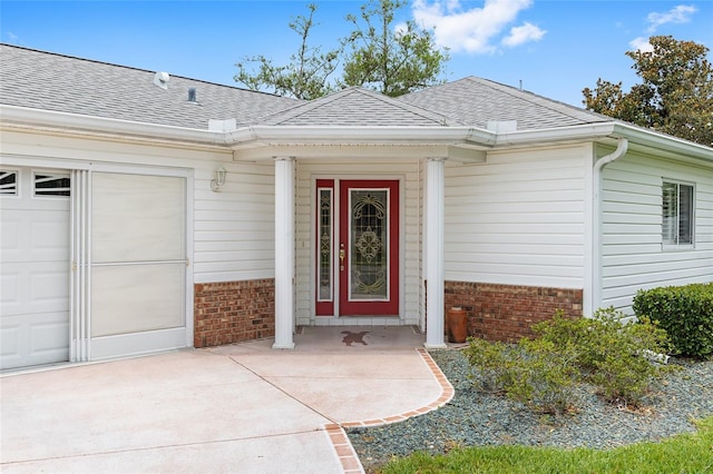 8608 SE 141st Street Rd, Summerfield, FL 34491 - property entrance featuring brick siding, a garage, roof with shingles, and concrete driveway