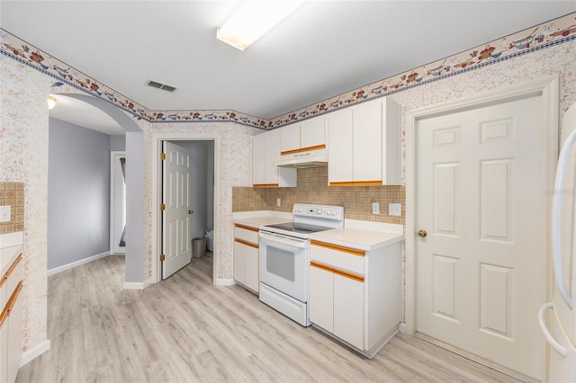 8608 SE 141st Street Rd, Summerfield, FL 34491 - kitchen featuring white appliances, under cabinet range hood, arched walkways, light wood-style floors, and light countertops