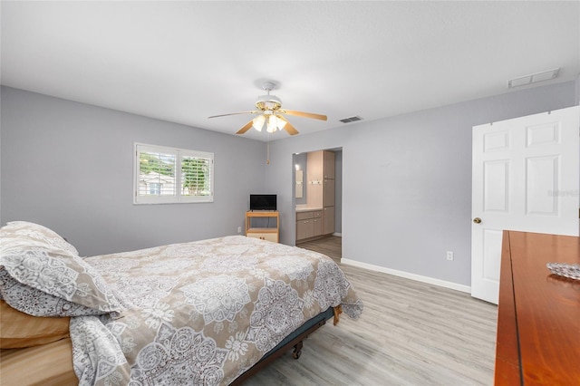 8608 SE 141st Street Rd, Summerfield, FL 34491 - bedroom with wood finished floors, baseboards, ceiling fan, and ensuite bathroom