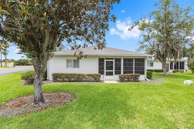 8608 SE 141st Street Rd, Summerfield, FL 34491 - back of property with a sunroom, a yard, and a shingled roof