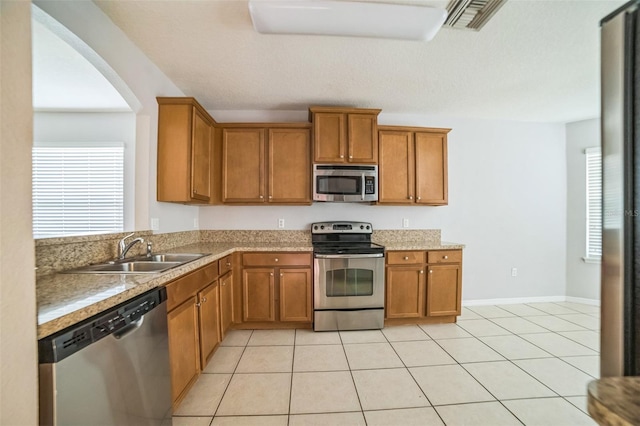 236 Savannah Preserve Loop, Davenport, FL 33837 - kitchen with appliances with stainless steel finishes, brown cabinets, plenty of natural light, and a sink