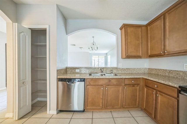 236 Savannah Preserve Loop, Davenport, FL 33837 - kitchen featuring dishwasher, brown cabinets, light tile patterned floors, a sink, and a chandelier