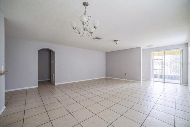 236 Savannah Preserve Loop, Davenport, FL 33837 - spare room featuring arched walkways, light tile patterned floors, a chandelier, and baseboards