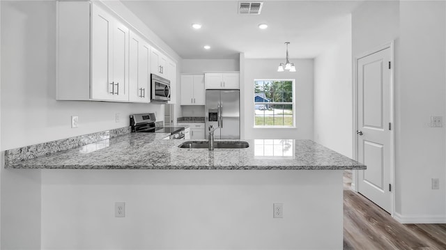 41346 Persimmon St, Eustis, FL 32736 - kitchen featuring appliances with stainless steel finishes, a sink, a peninsula, white cabinetry, and dark wood finished floors