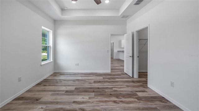 41346 Persimmon St, Eustis, FL 32736 - unfurnished bedroom with a raised ceiling, wood finished floors, a spacious closet, and baseboards