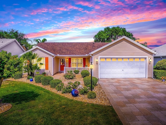 1206 Thompson Ave, The Villages, FL 32162 - ranch-style home with covered porch, a garage, decorative driveway, and a yard