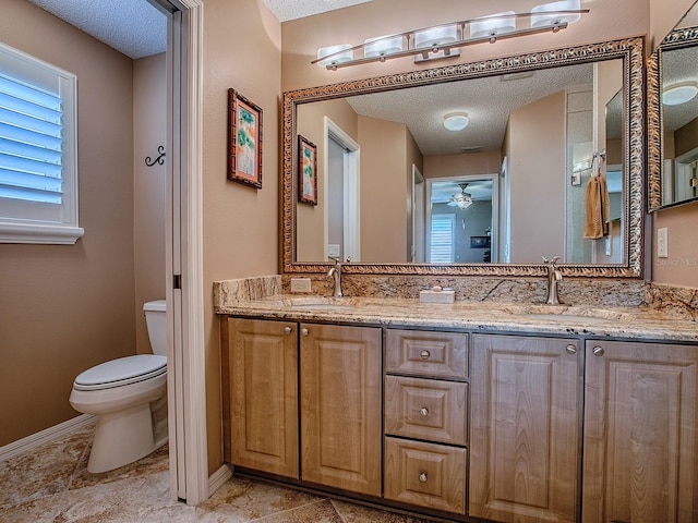 1206 Thompson Ave, The Villages, FL 32162 - bathroom featuring toilet, a textured ceiling, double vanity, a ceiling fan, and plenty of natural light