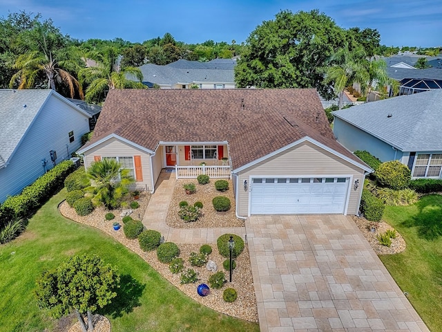 1206 Thompson Ave, The Villages, FL 32162 - view of front of property featuring covered porch, a garage, driveway, and a front lawn
