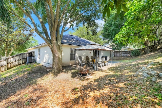 1311 Rain Forest Ln, Minneola, FL 34715 - rear view of house with a fire pit, a gazebo, a fenced backyard, and a patio area