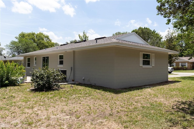 2701 S Dellwood Dr, Eustis, FL 32726 - back of property featuring a yard, a shingled roof, and concrete block siding