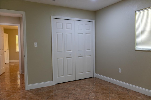 2701 S Dellwood Dr, Eustis, FL 32726 - unfurnished bedroom with a closet, baseboards, and tile patterned flooring