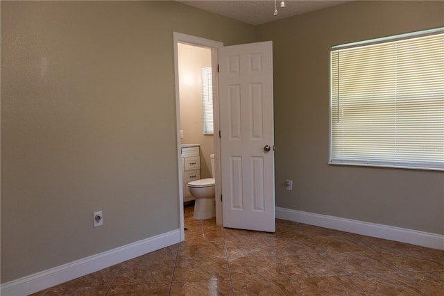 2701 S Dellwood Dr, Eustis, FL 32726 - unfurnished bedroom featuring baseboards and connected bathroom