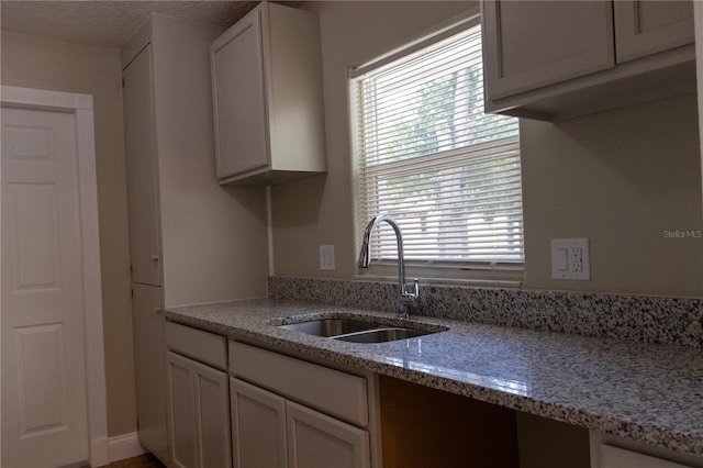 2701 S Dellwood Dr, Eustis, FL 32726 - kitchen featuring a sink, light stone countertops, and white cabinetry