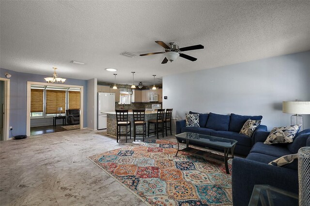 2003 Cordero Ct, The Villages, FL 32159 - living room featuring a ceiling fan, a chandelier, and a textured ceiling