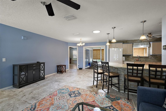 2003 Cordero Ct, The Villages, FL 32159 - living area with a ceiling fan, a chandelier, and a textured ceiling