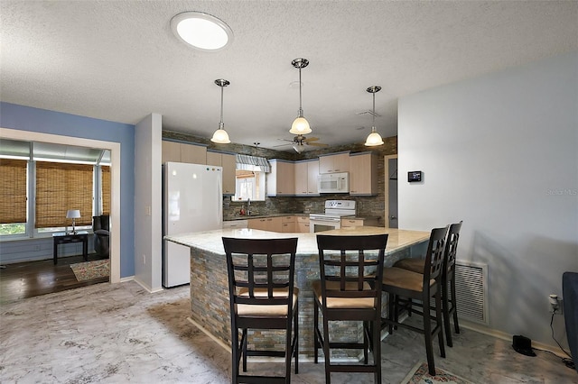 2003 Cordero Ct, The Villages, FL 32159 - kitchen with white appliances, a peninsula, backsplash, ceiling fan, and a breakfast bar